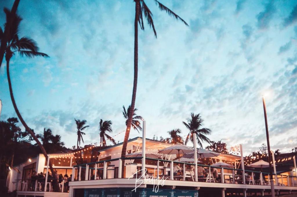 a palm tree in front of a building at Base Airlie Beach in Airlie Beach