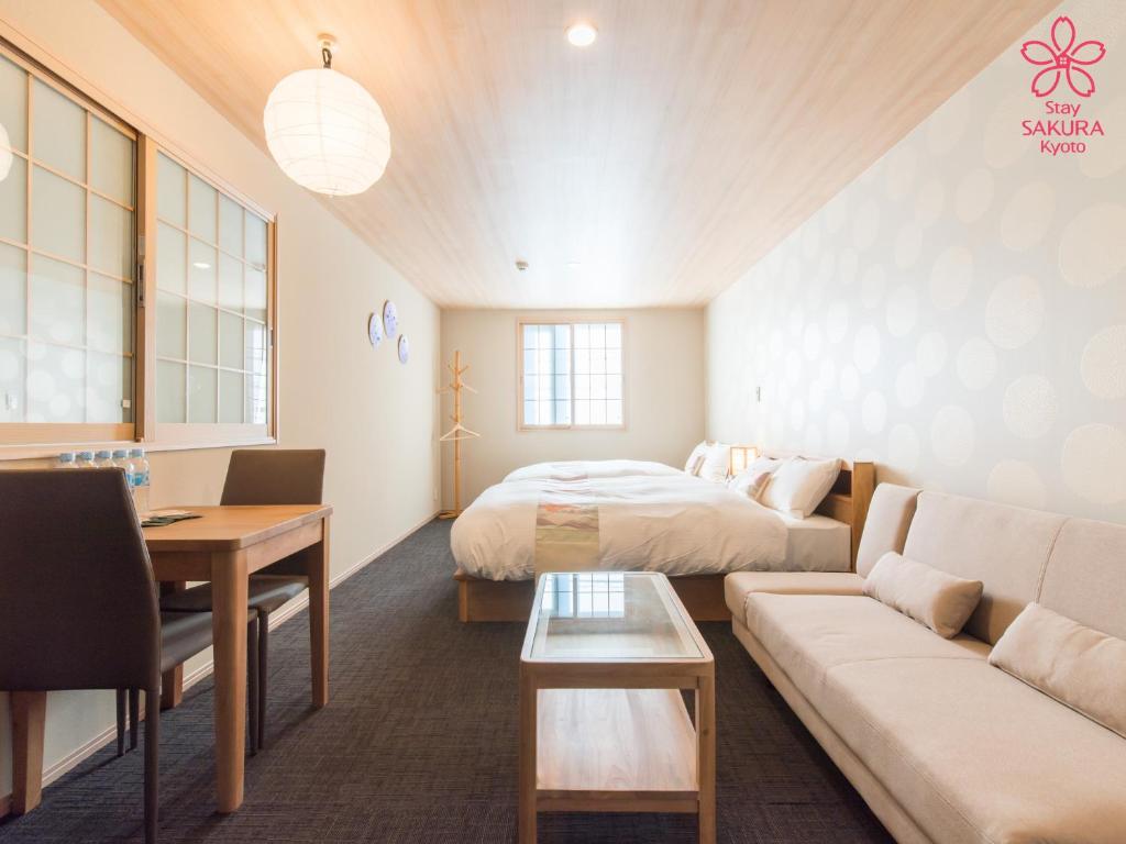 a living room with a bed and a couch at Stay SAKURA Kyoto Station South I in Kyoto