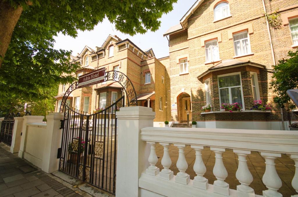 a white fence in front of a house at Adria Hotel in London