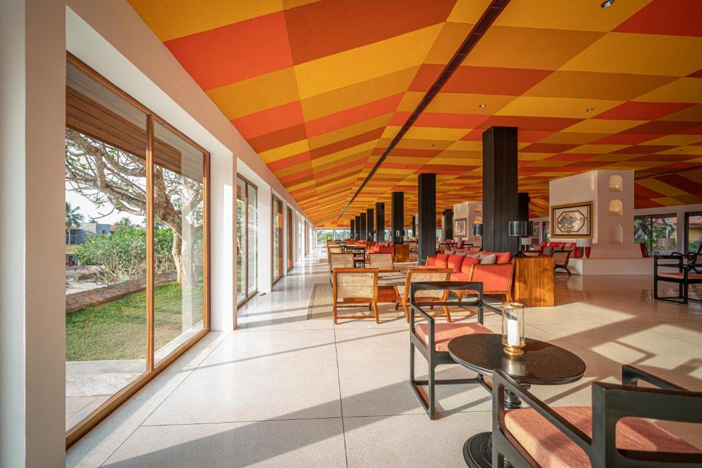 a restaurant with a colorful ceiling and tables and chairs at Cinnamon Bentota Beach - Signature Selection in Bentota