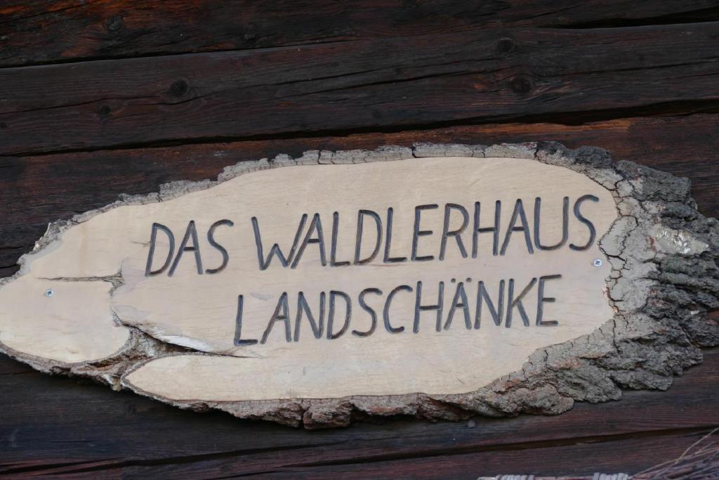 a sign on the side of a wooden wall at Das Waldlerhaus in Lam