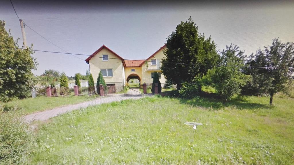 ein Haus auf einem Feld mit einem Hof in der Unterkunft RAMAR in Bodzentyn