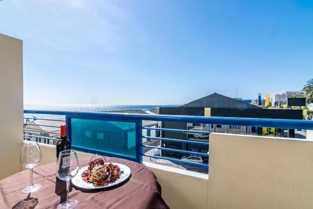 a table with a plate of food and wine glasses at Banana Beach in Marbella