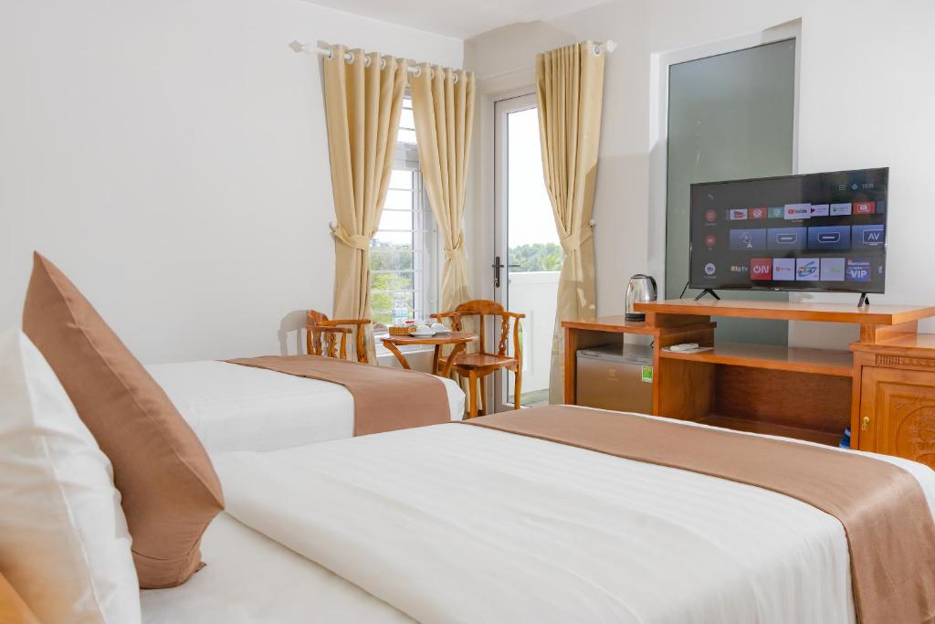 pokój hotelowy z 2 łóżkami i telewizorem z płaskim ekranem w obiekcie Hopapa Hotel w Duong Dong