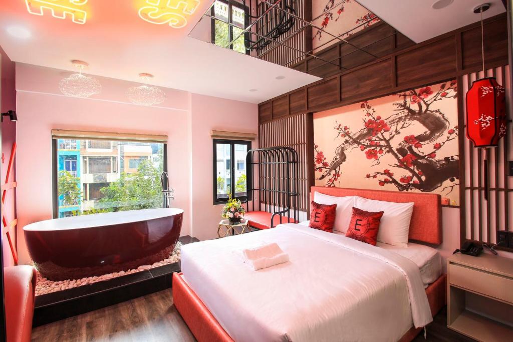 a bedroom with a tub and a bed and a bath room at EROS Hotel - Love Hotel in Ho Chi Minh City
