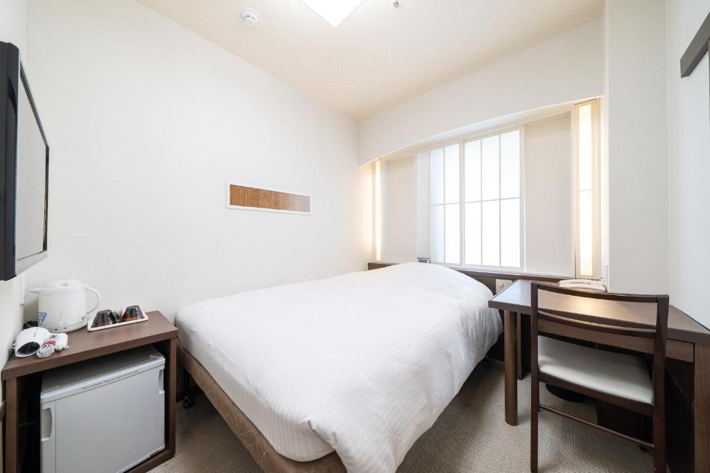 a bedroom with a white bed and a window at Hotel Sunlite Shinjuku in Tokyo