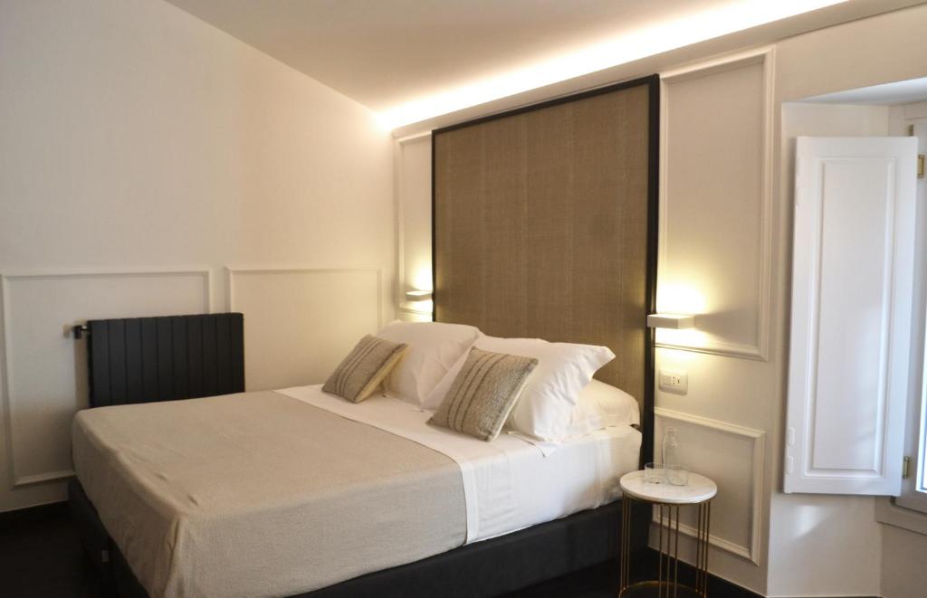 a bedroom with a white bed with a window at PALAZZO DELLE SIRENE Deluxe Apartment & Boutique Rooms in Levanto