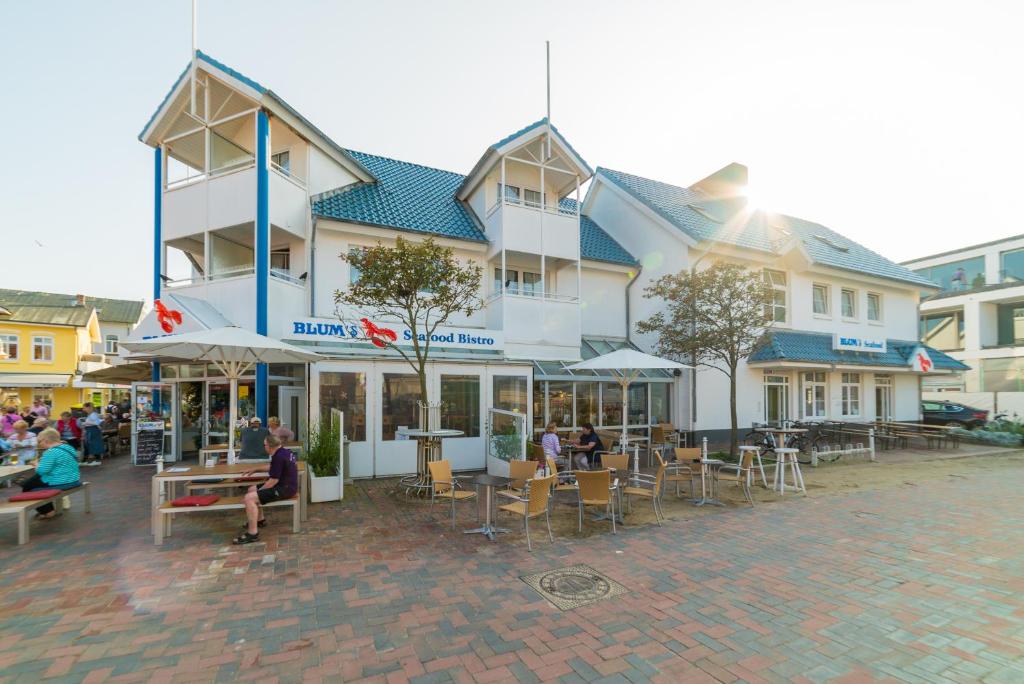 ein Gebäude mit Tischen und Stühlen davor in der Unterkunft Stadthaus in Westerland