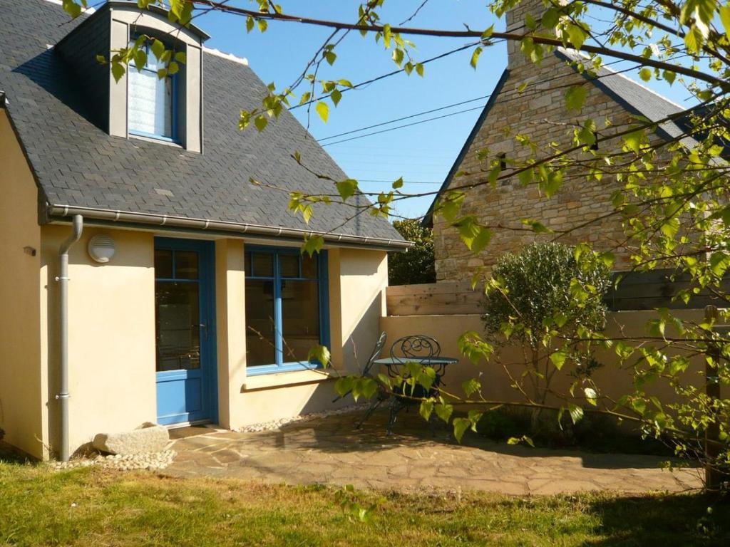 una casa con una puerta azul y un banco en L'olivier, en Tréffiagat