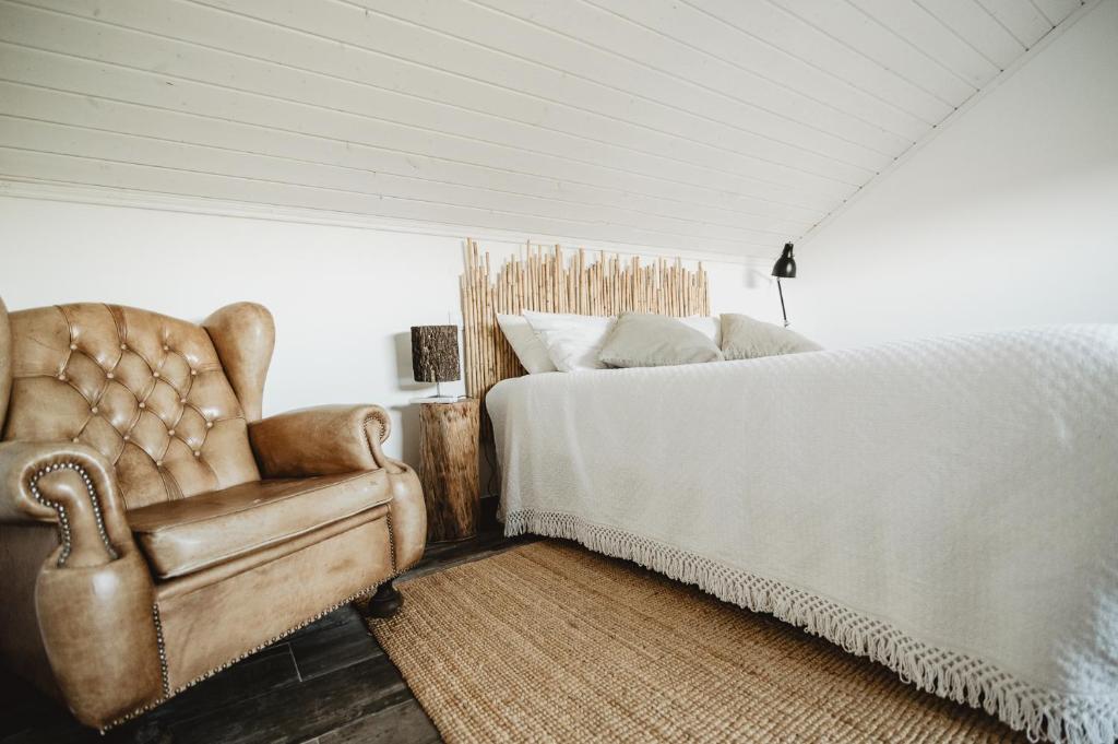un dormitorio con una cama y una silla en The ONE - Country House, en Grândola