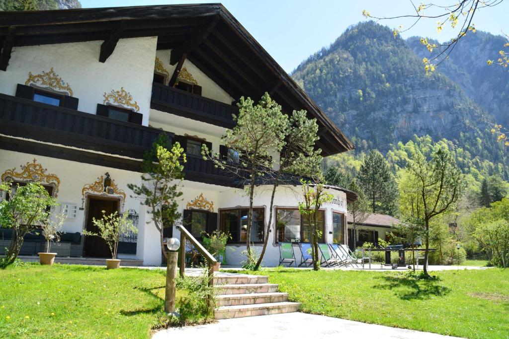 a building with a staircase in front of a mountain at Pension Almhof Baumgarten in Bad Reichenhall