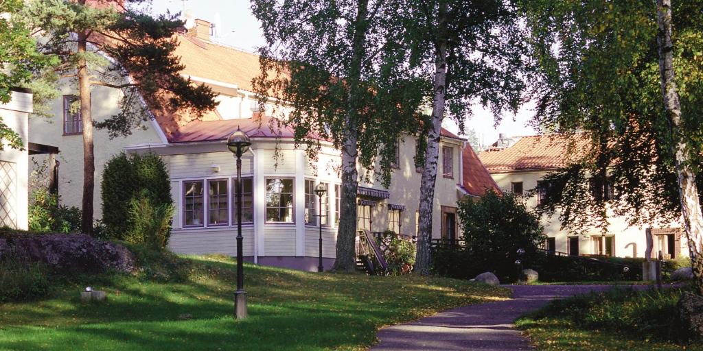 a white house with a street light in front of it at Nynäsgården Hotell & Konferens in Nynäshamn