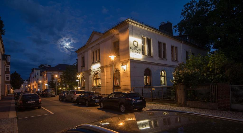 a building with cars parked on a street at night at Parkhotel Plauen in Plauen