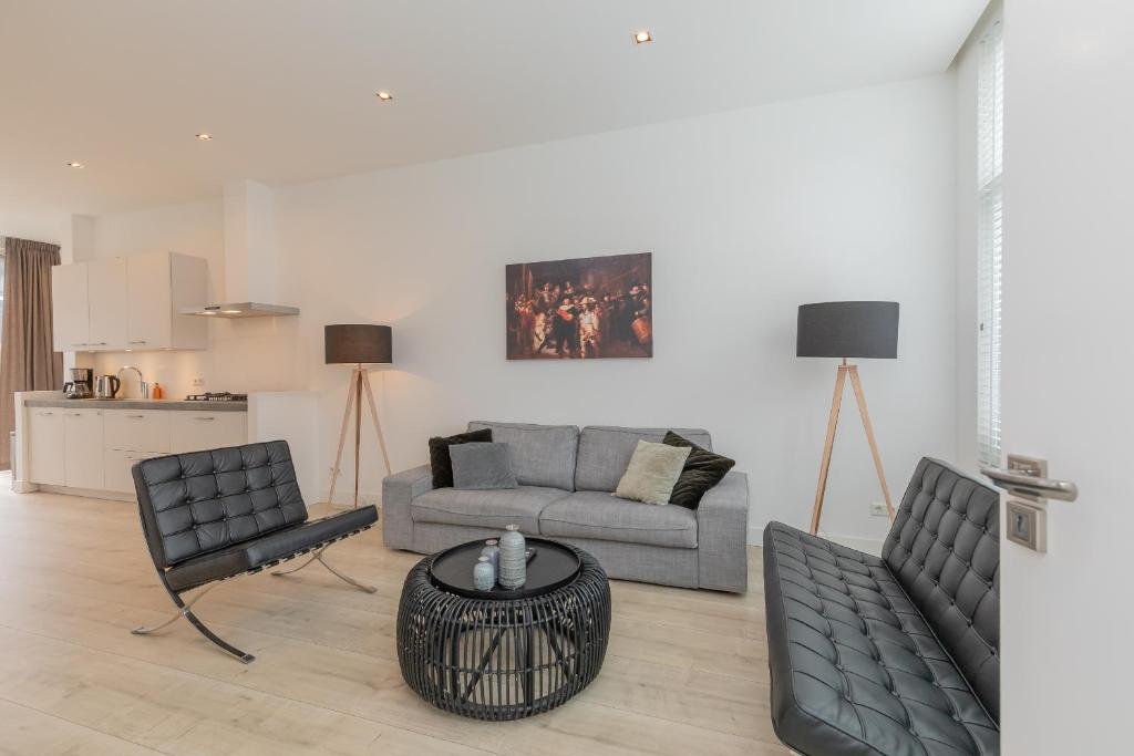 ein Wohnzimmer mit einem Sofa, Stühlen und einem Tisch in der Unterkunft Zandvoort Village Apartments in Zandvoort
