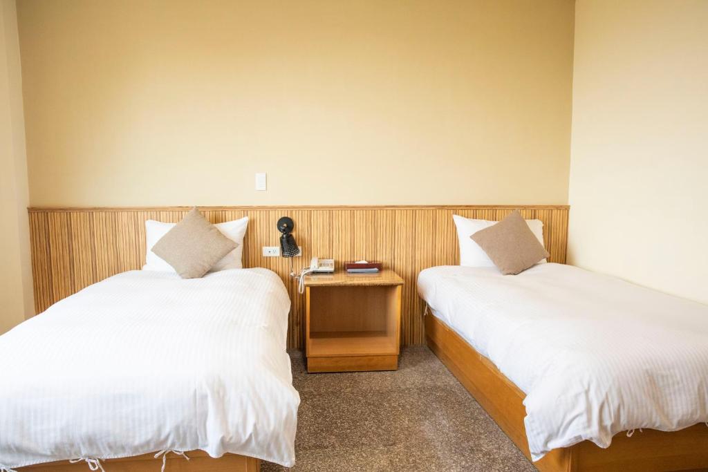 2 Betten nebeneinander in einem Zimmer in der Unterkunft Holiday Hotel in Insel Nangan