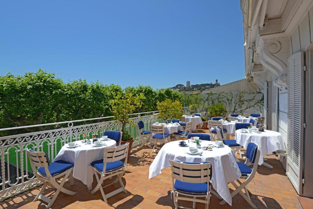 a group of tables and chairs on a balcony at Hotel Splendid in Cannes