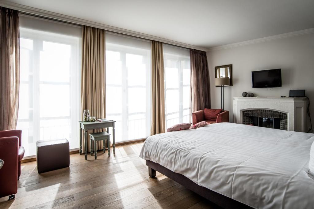 une chambre d'hôtel avec un lit et une cheminée dans l'établissement Hotel de la Paix, à Poperinge
