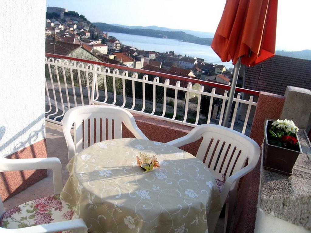 a table and chairs on a balcony with a view at Apartments Madlena in Šibenik