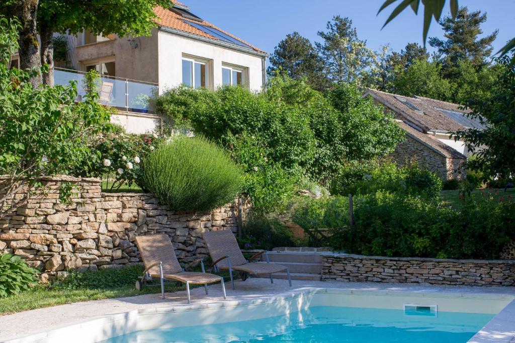 een huis met 2 stoelen en een zwembad bij La Terre d'Or in Beaune