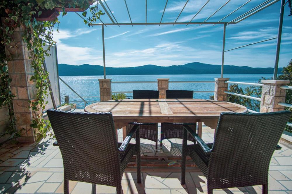 - une table et des chaises sur une terrasse avec vue sur l'eau dans l'établissement 3 Bedroom Beach House with private sea access, à Slano