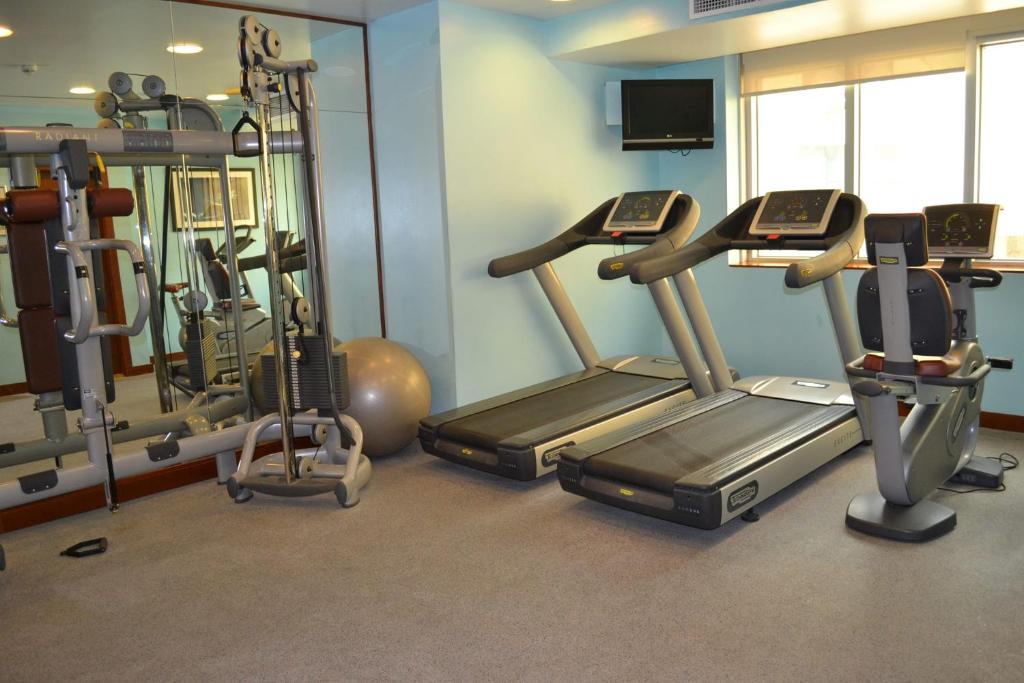 a gym with several tread machines in a room at Al Rawda Arjaan by Rotana, Abu Dhabi in Abu Dhabi