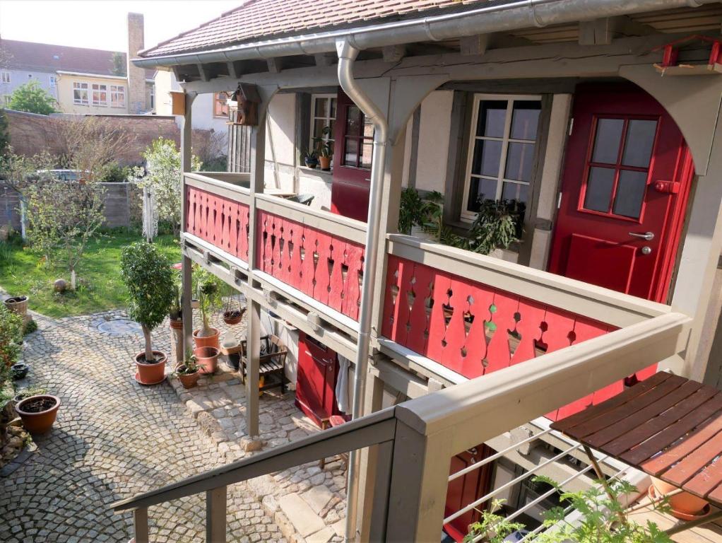 uma casa com uma porta vermelha e um alpendre em Ferienwohnung Bachmanns Witwe em Naumburg