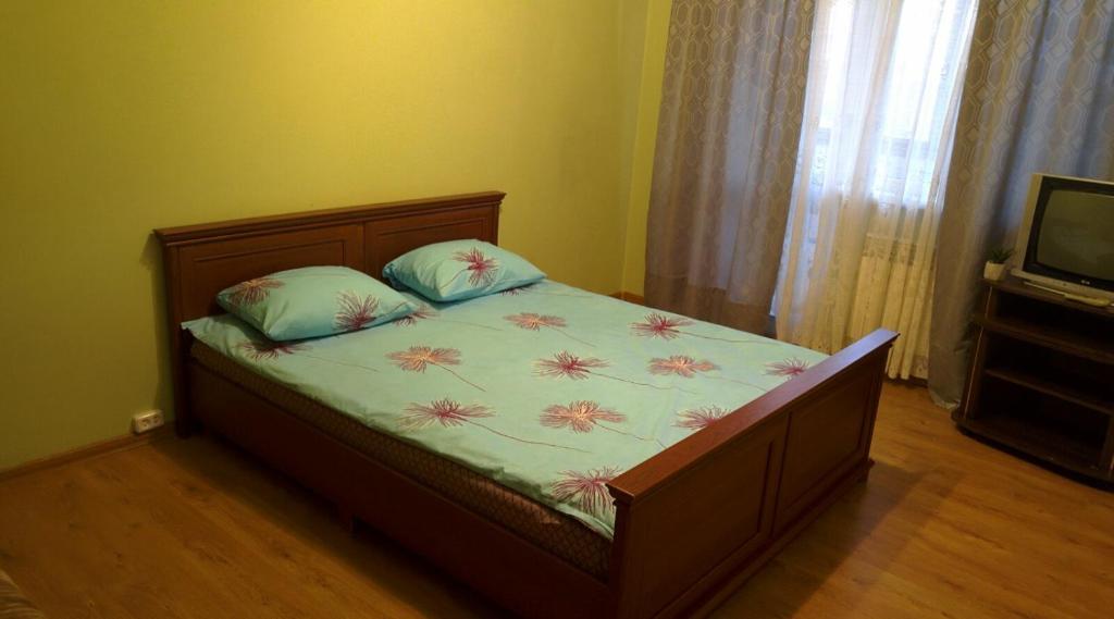 sypialnia z łóżkiem i telewizorem w obiekcie Уютная квартира рядом с метpo Холодная гора w Charkowie