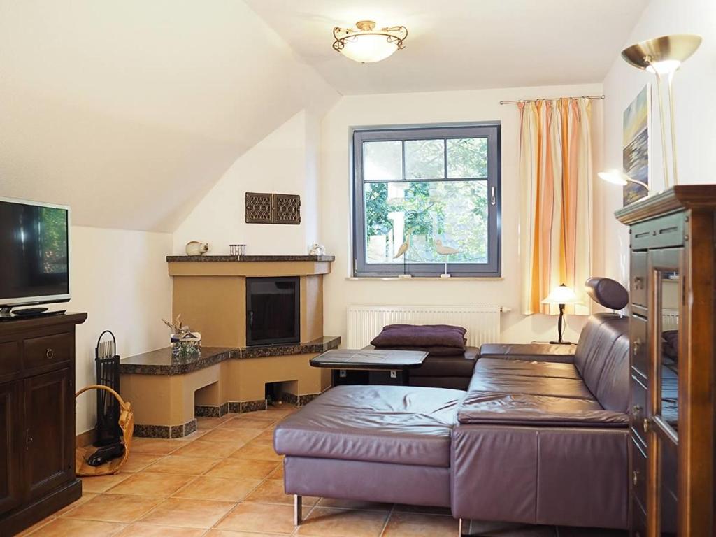 a living room with a couch and a tv at Haus Komoran Wohnung 3 in Prerow