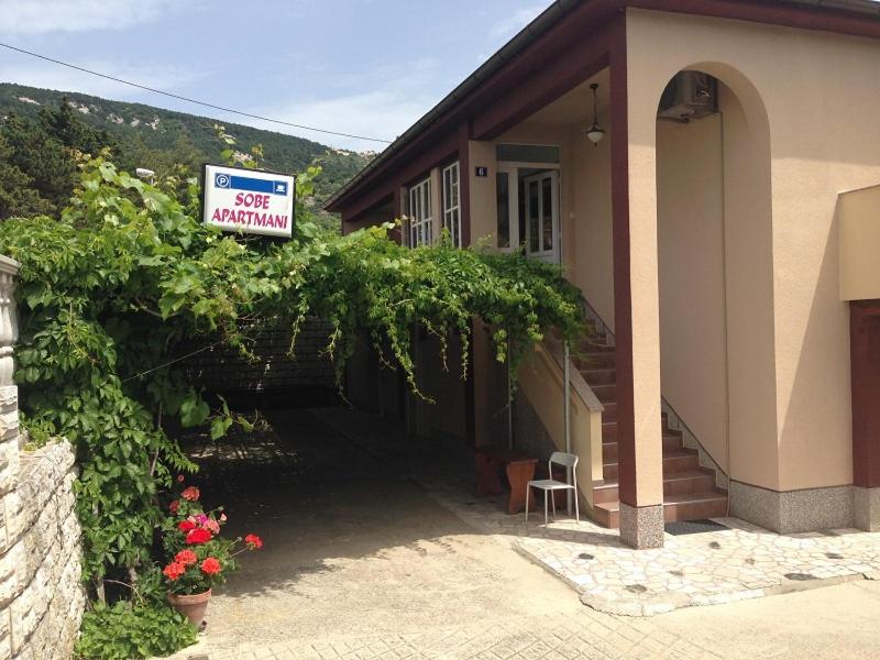 a house with a sign on the side of it at Summer rooms Baška 2 in Baška