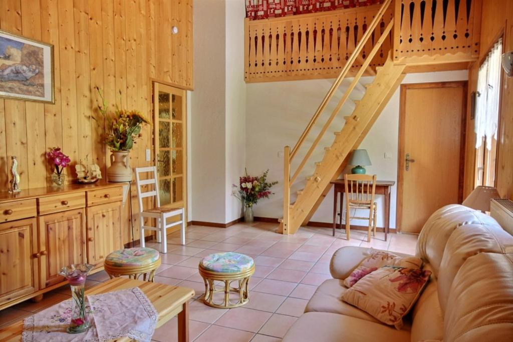 a living room with a couch and a staircase at GRAND APPARTEMENT - WIFI -SAINT JEAN D'AULPS - 12 Personnes - HIRONDELLE in Saint-Jean-d'Aulps
