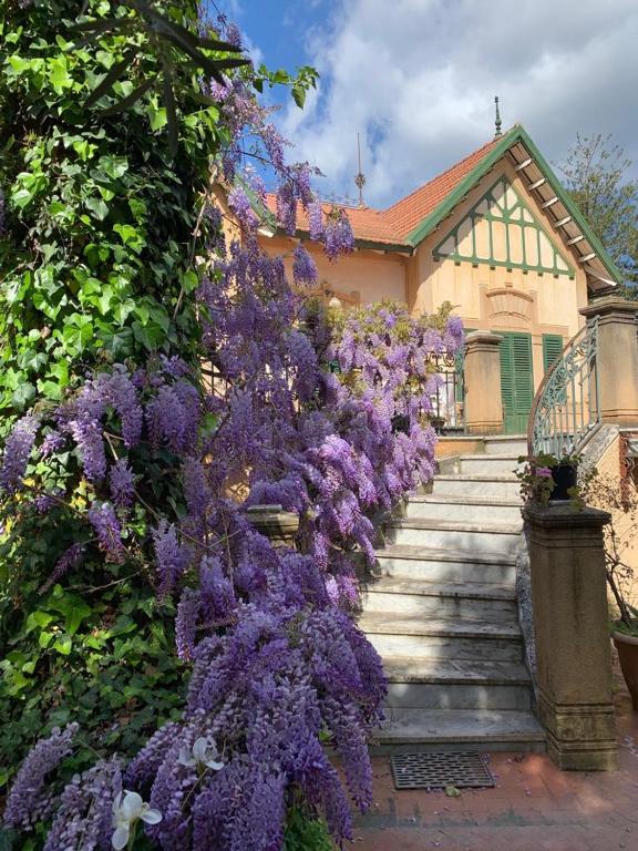 a bunch of purple flowers on the side of a house at mondello beach luxury apartments in Palermo
