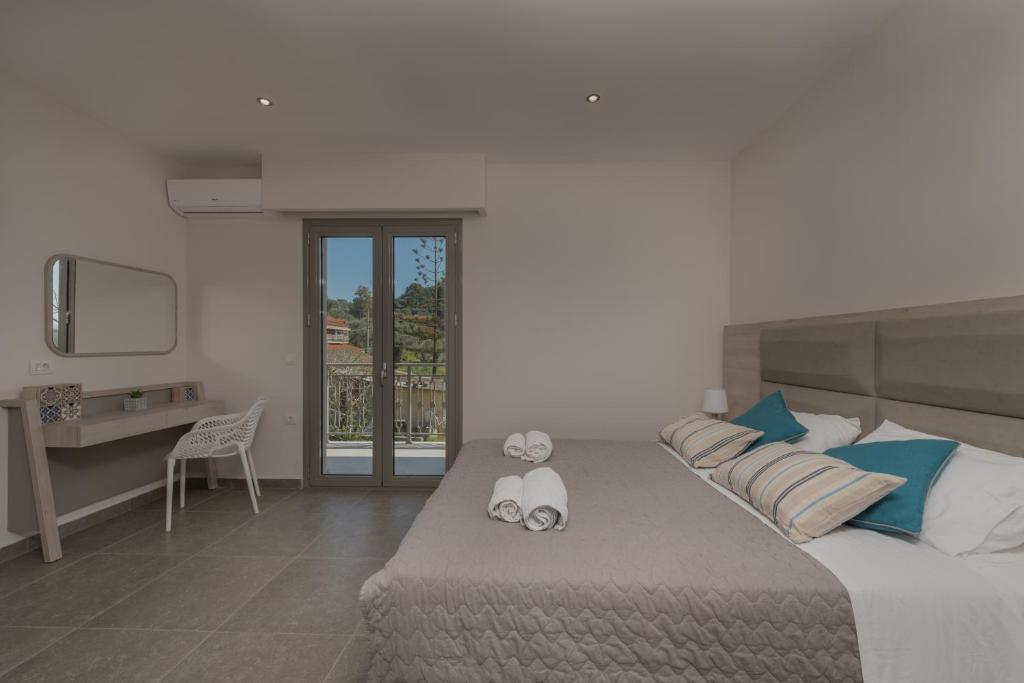 a bedroom with a large bed with two stuffed animals on it at Casa 77 Zante by Karras Hotels in Zakynthos Town