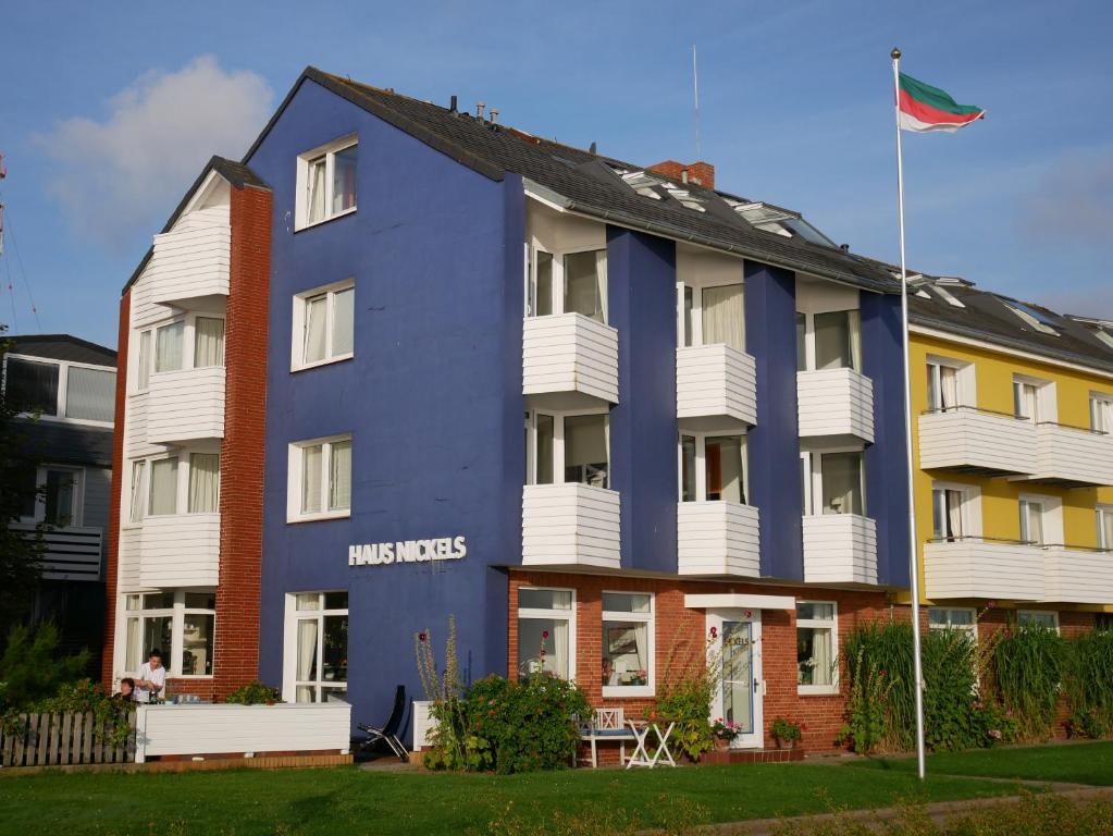 ein farbenfrohes Gebäude mit einer Flagge davor in der Unterkunft Haus Nickels in Helgoland