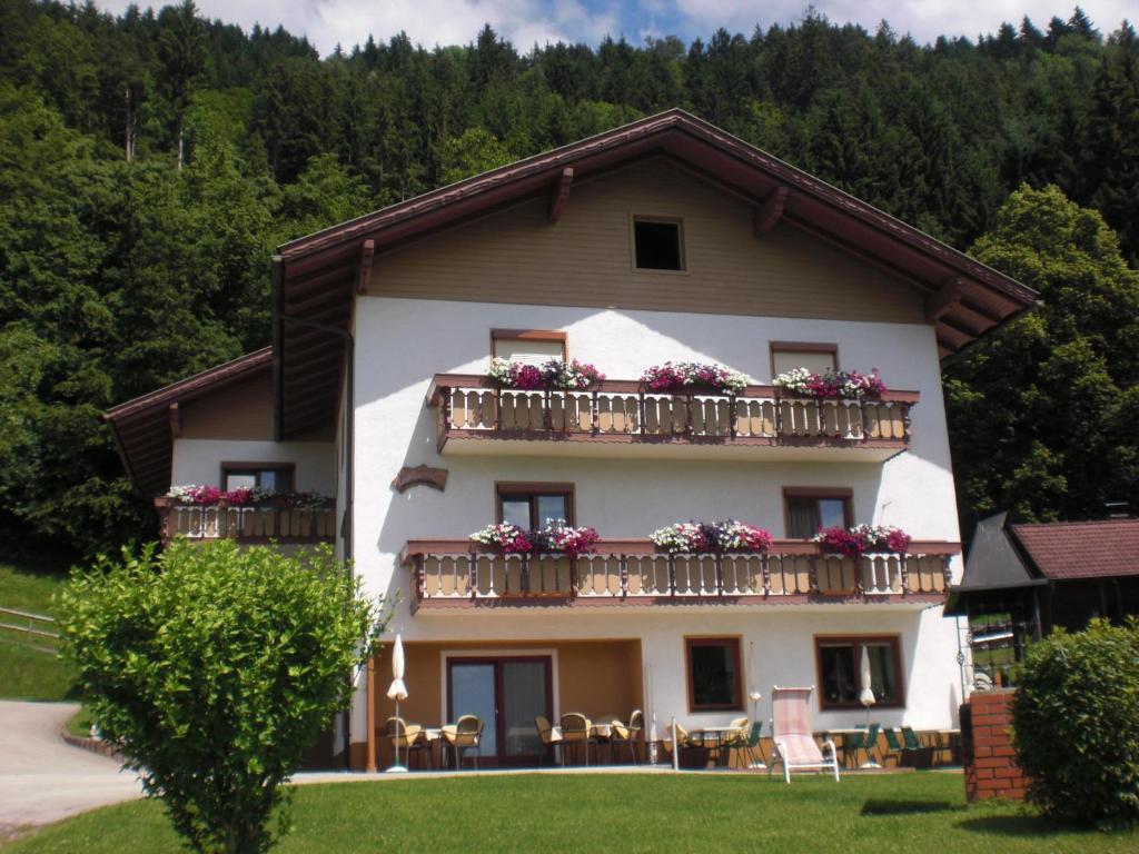 a building with a balcony with flowers on it at Ferienwohnung Landhaus Sorli in Bodensdorf