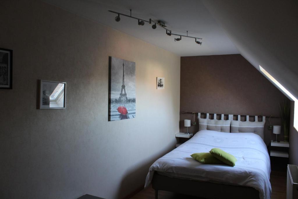 a bedroom with a bed in a room with the eiffel tower at Maison du Lavoir Disneyland in Bailly-Romainvilliers