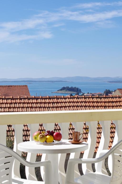 a table with fruit on top of a balcony at Apartments Verita in Pakoštane