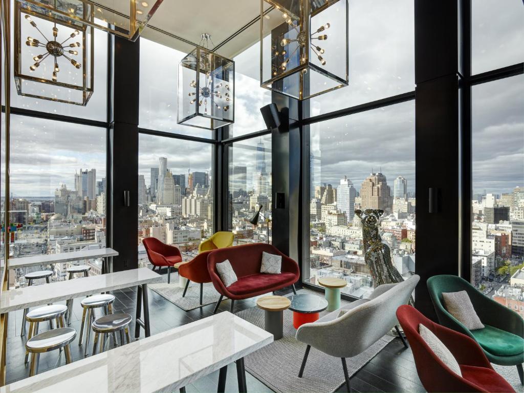 a hotel room with tables and chairs and umbrellas at citizenM New York Bowery in New York