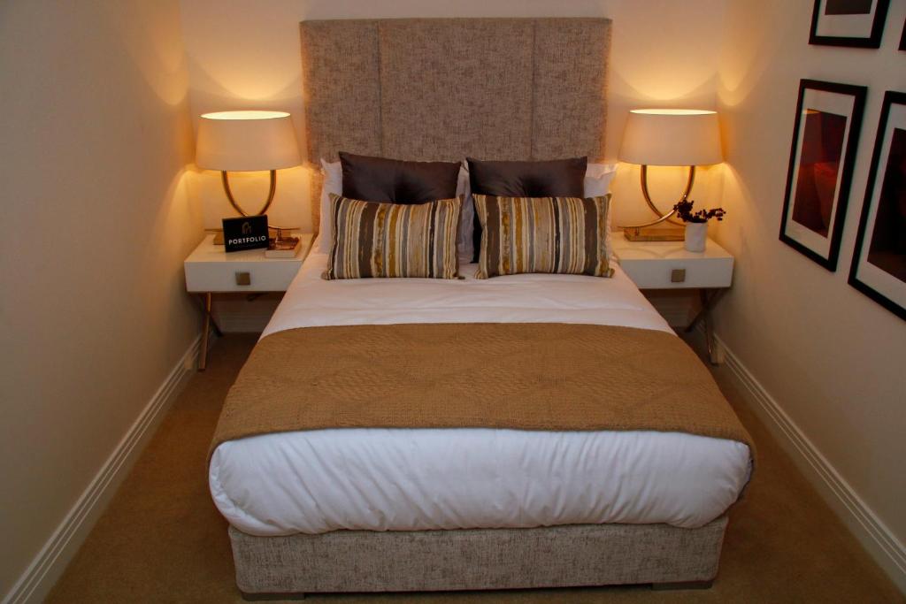 a bedroom with a large bed with two lamps at Portfolio Apartments - Stevenage Town Centre in Stevenage
