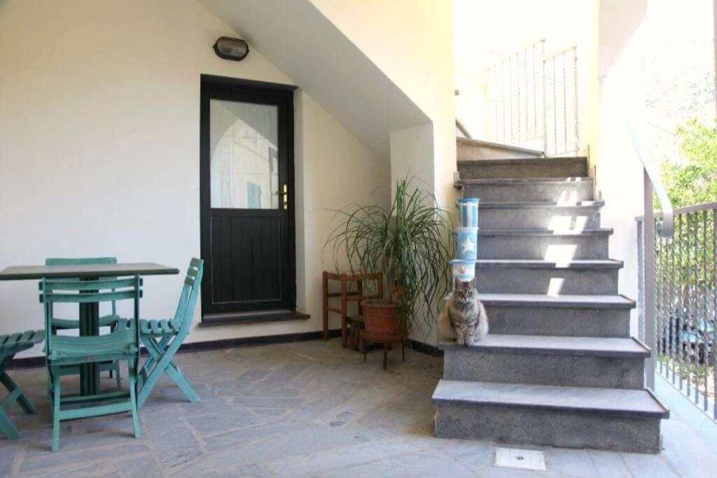 porche con mesa, escalera y puerta en Le case della Lizza - Casa Blu, en Levanto