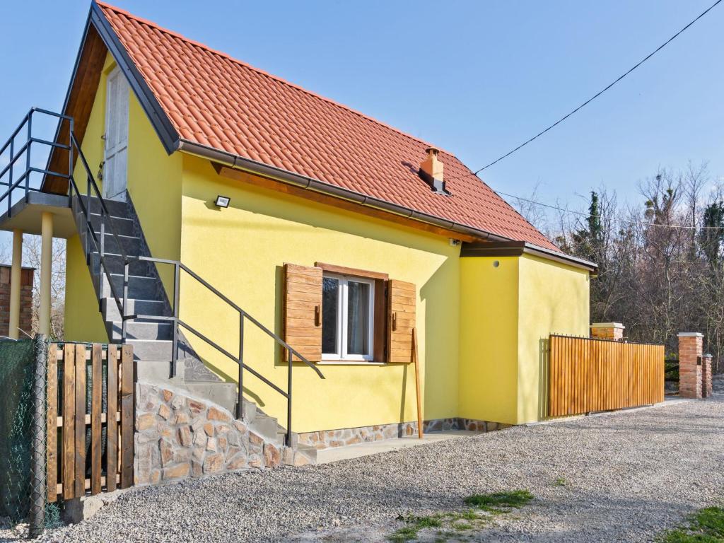 a small yellow house with a wooden fence at Rustic Holiday Home in Donja Stubica with Terrace in Donja Stubica