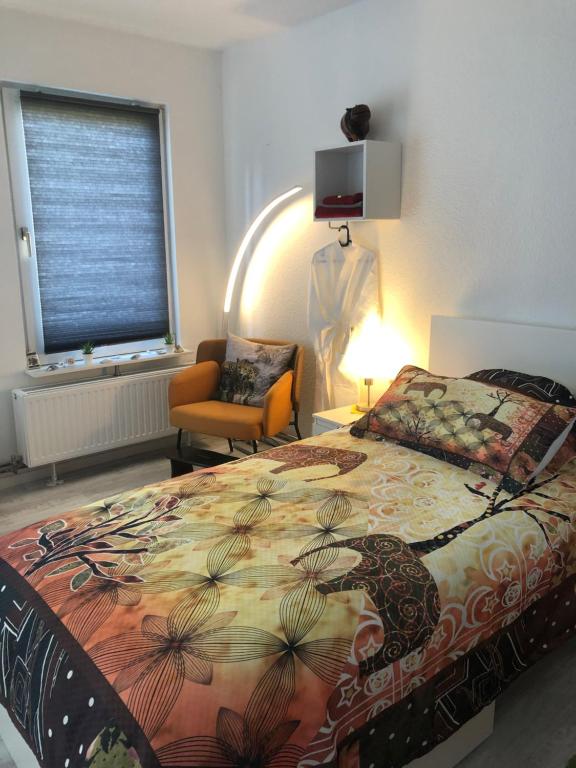 een slaapkamer met een bed, een stoel en een raam bij Maggies-Apartment-Hannover in Hannover