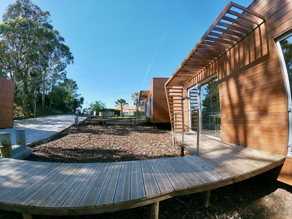 a wooden deck next to a house with a building at Golden Halcyon - Ericeira Villas in Ericeira