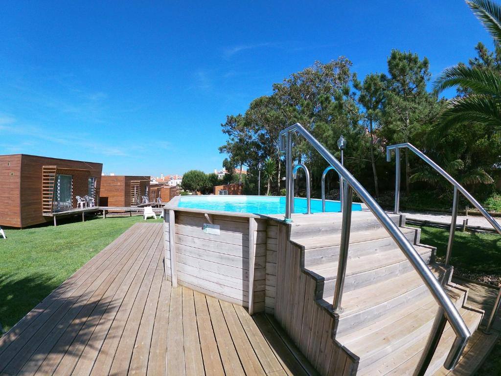 a staircase leading to a swimming pool on a wooden deck at Golden Halcyon - Ericeira Villas in Ericeira