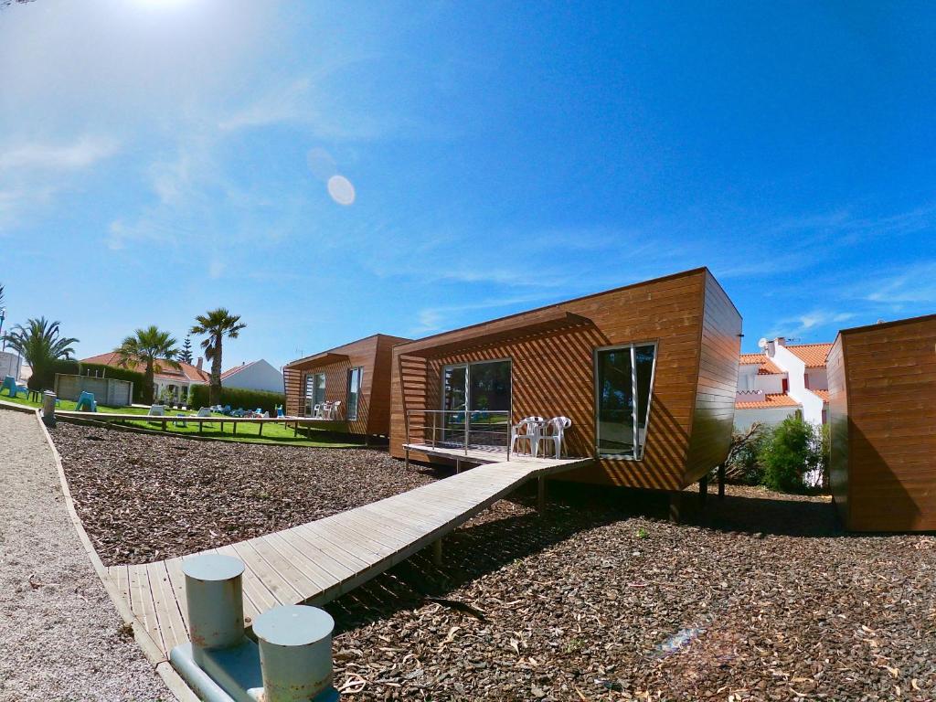 a tiny house with a wooden porch and a deck at Golden Halcyon - Ericeira Villas in Ericeira
