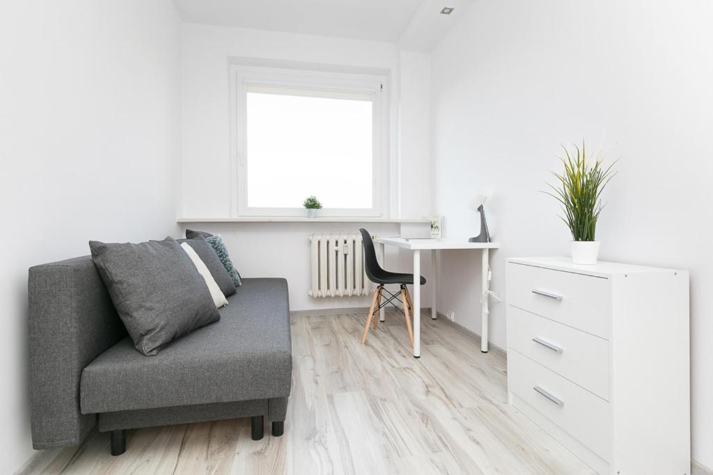 a living room with a chair and a desk at Rooms4Less in Gdańsk
