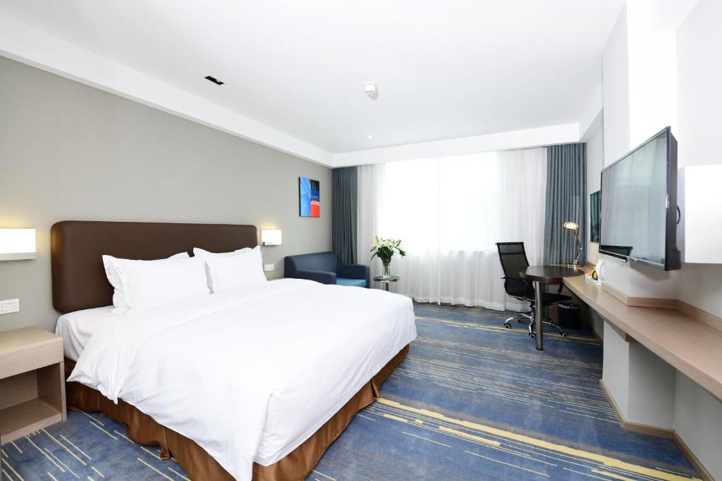 a hotel room with a bed and a flat screen tv at Holiday Inn Express Changchun High-Tech Zone by IHG in Changchun