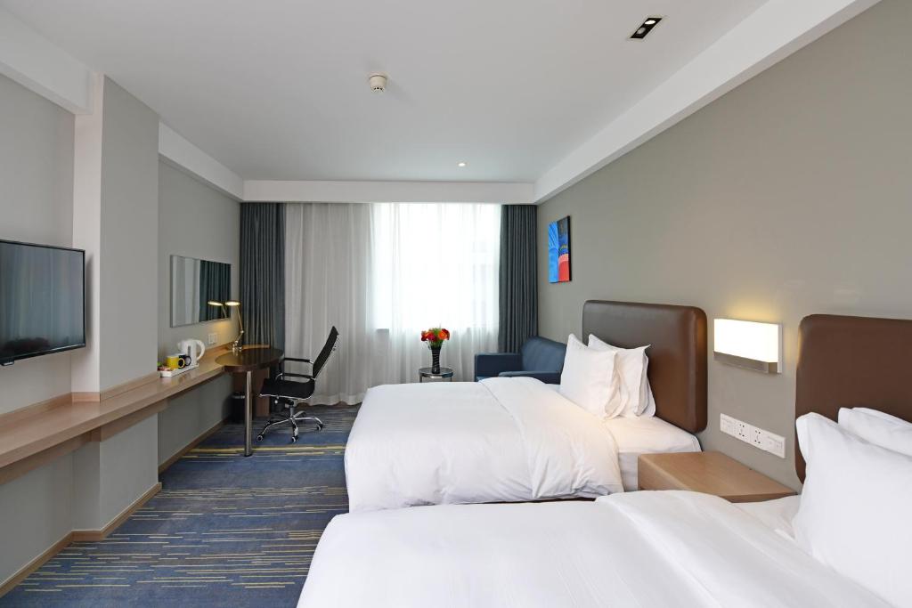 a hotel room with two beds and a television at Holiday Inn Express Changchun High-Tech Zone by IHG in Changchun