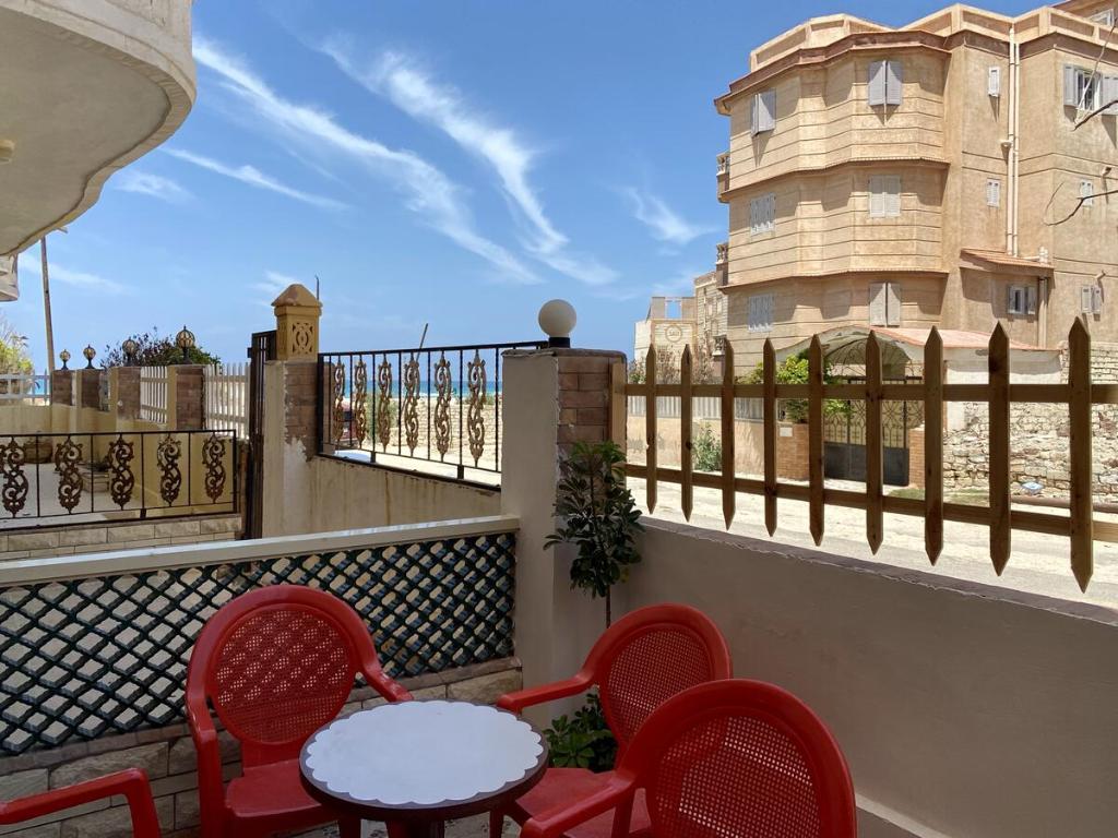 a balcony with a table and chairs and a building at Seaside Two-Bedroom Chalet Sidi Krir in Sidi Krir 