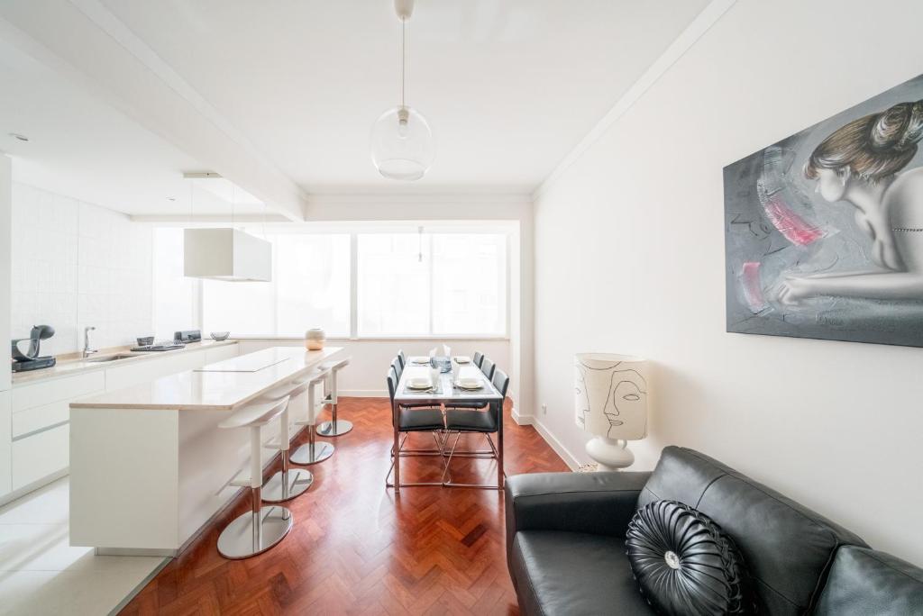 リスボンにあるCentral Family and Executive Apartmentの白いキッチン(黒いソファ、テーブル付)