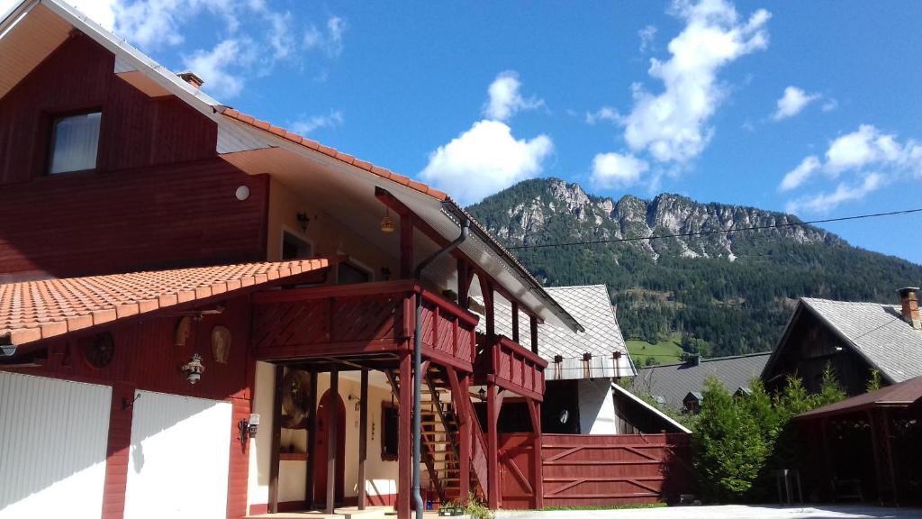 un bâtiment en bois avec une montagne en arrière-plan dans l'établissement Zajček Apartma, à Mojstrana